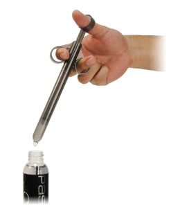 Hand holding a syringe-like tool over a bottle