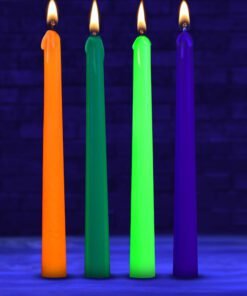 Four colorful candles burning in a dark setting