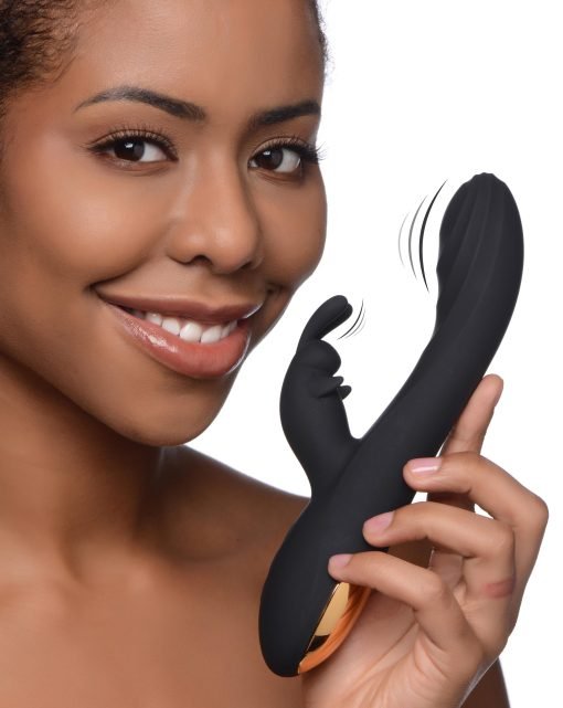 A woman smiling while holding a sleek black personal massager