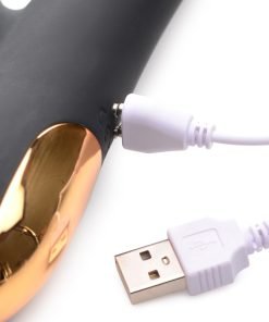 Close-up of a black and gold USB device with a charging cable connected