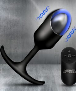 A sleek black vibrating plug with a remote control on a metallic background.