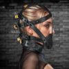 Profile view of a person wearing a black leather restraint harness with locks.
