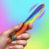 Colorful handheld vibrator against a gradient background