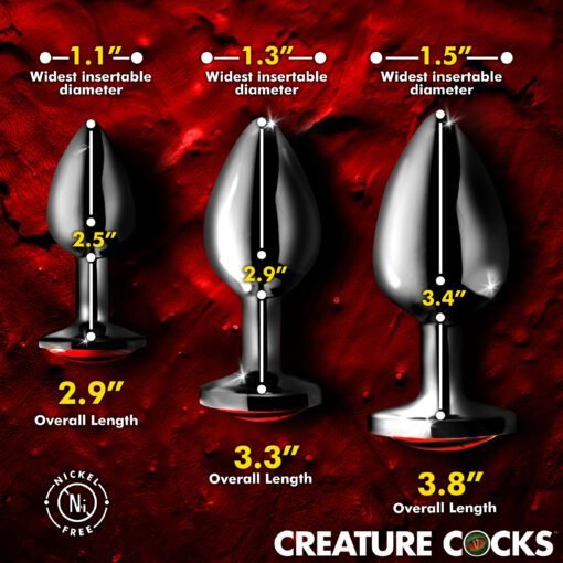 Three metallic anal plugs of varying sizes displayed on a red textured background.