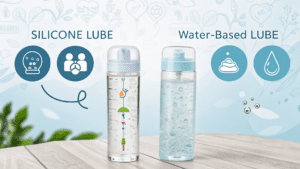 Bottles of silicone lube and water-based lube on a wooden surface with a soft background.