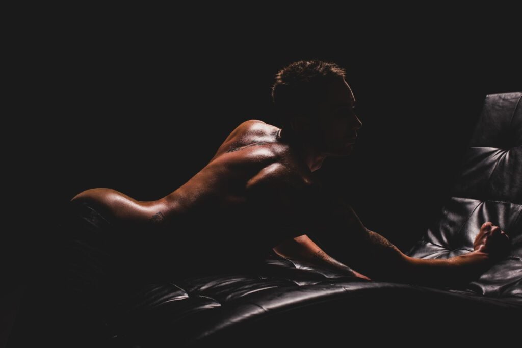 Silhouette of a person on a black leather chaise lounge