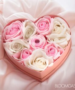 Heart-shaped box of pink and white roses with a decorative element in the center