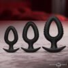 Three black silicone anal plugs of varying sizes