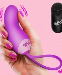 A woman holding a purple vibrating toy with a remote control against a pink background.