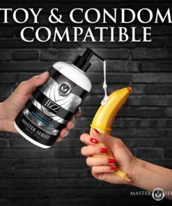 A bottle of lubricant with a hand holding a banana in a condom, against a brick wall background.